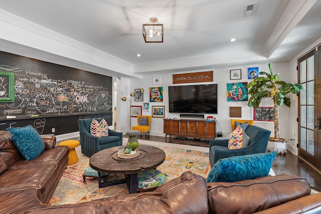 living room with french doors and a raised ceiling