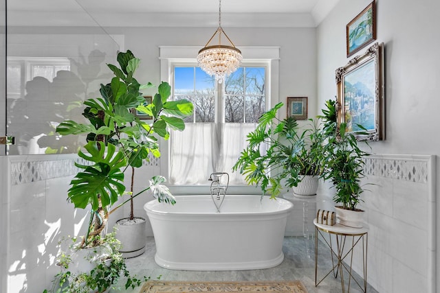 bathroom with a tub and a chandelier