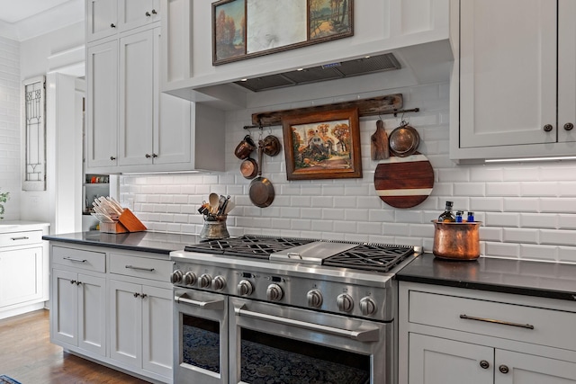 kitchen featuring crown molding, light hardwood / wood-style flooring, white cabinets, decorative backsplash, and range with two ovens