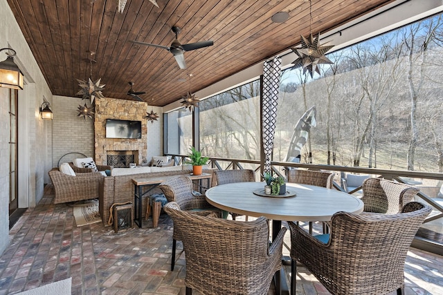 view of patio with a bar, ceiling fan, and an outdoor stone fireplace