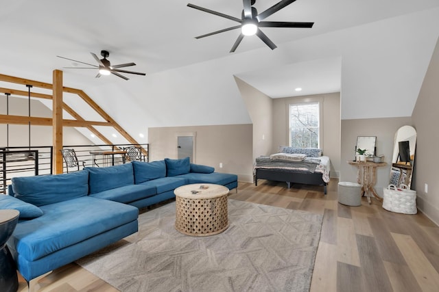 living room featuring lofted ceiling, light hardwood / wood-style flooring, and ceiling fan