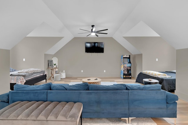 living room with ceiling fan, vaulted ceiling, and light hardwood / wood-style flooring