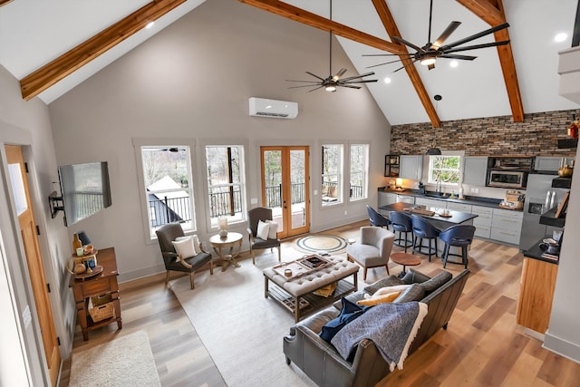 living room featuring french doors, light hardwood / wood-style flooring, an AC wall unit, beamed ceiling, and ceiling fan