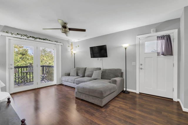 living room featuring dark wood-type flooring and ceiling fan