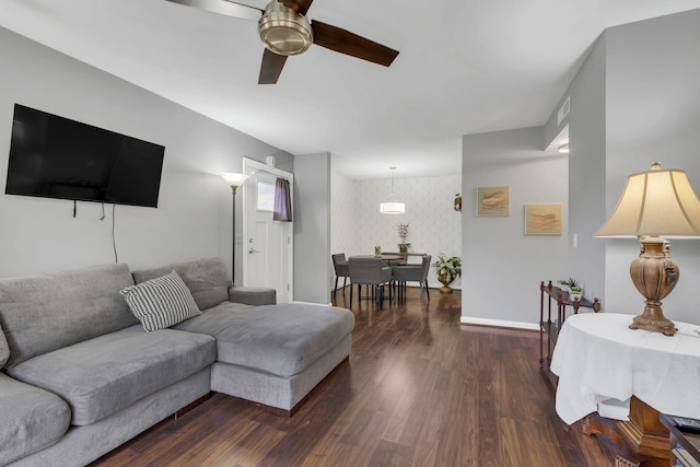 living room featuring dark wood-type flooring and ceiling fan