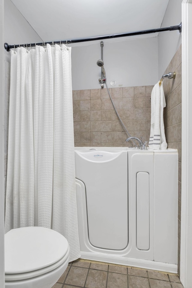 bathroom with tile patterned flooring, toilet, and walk in shower