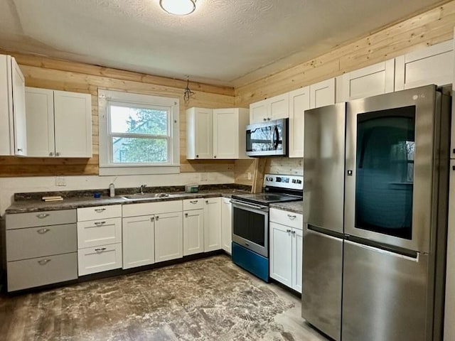 kitchen with sink, a textured ceiling, white cabinets, and appliances with stainless steel finishes