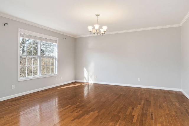 spare room with hardwood / wood-style flooring, ornamental molding, and an inviting chandelier