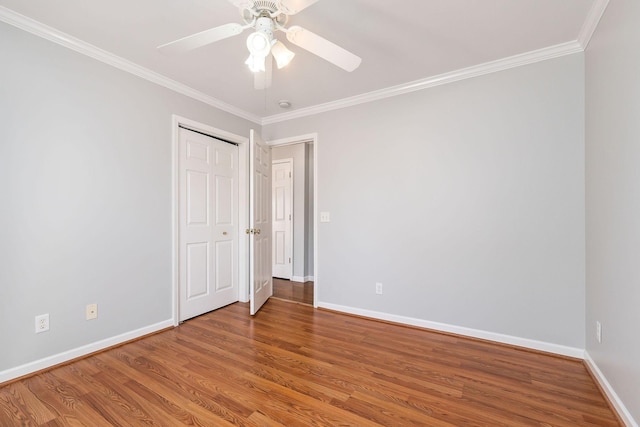 spare room with crown molding, ceiling fan, and wood-type flooring