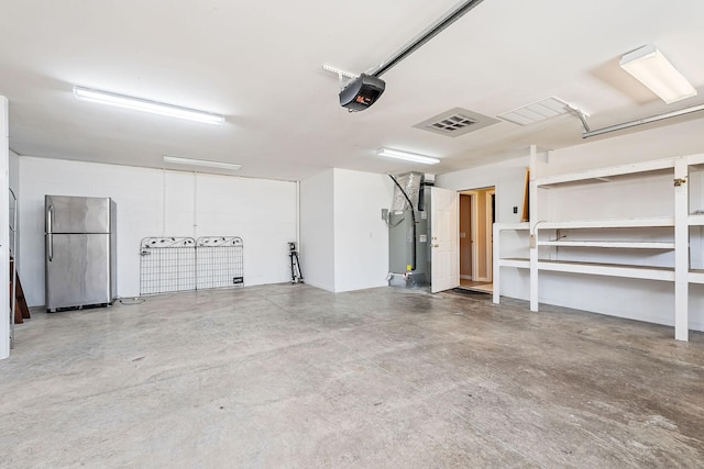 garage featuring a garage door opener and stainless steel refrigerator