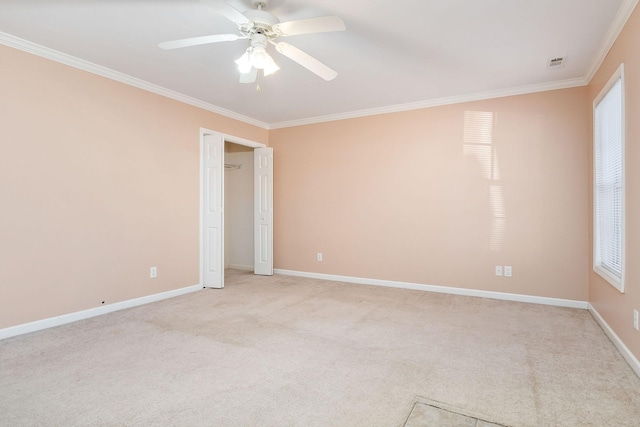 empty room featuring light carpet, ornamental molding, and ceiling fan