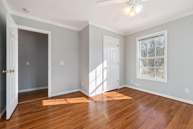 empty room featuring wood-type flooring, ceiling fan, and crown molding