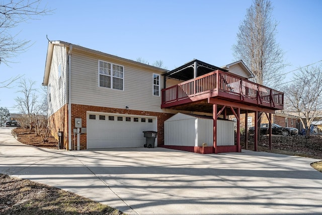 rear view of property with a garage and a wooden deck