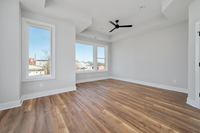 interior space featuring a tray ceiling, ceiling fan, and hardwood / wood-style flooring