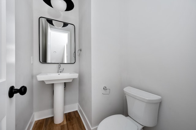 bathroom featuring hardwood / wood-style flooring and toilet