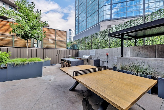 view of patio with a grill, area for grilling, and a bar