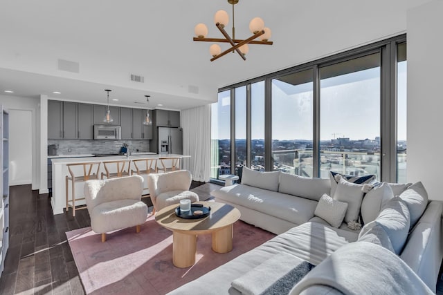 living room with floor to ceiling windows, dark hardwood / wood-style floors, and a chandelier