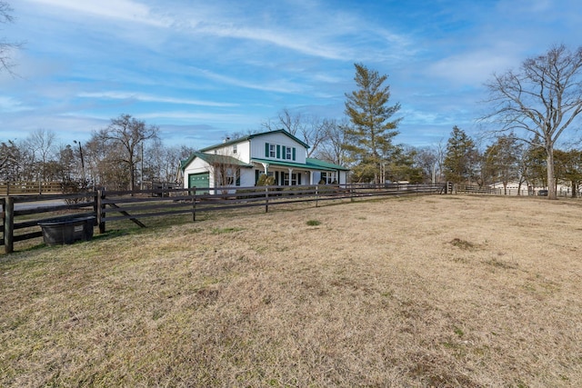 view of yard featuring a rural view and a garage