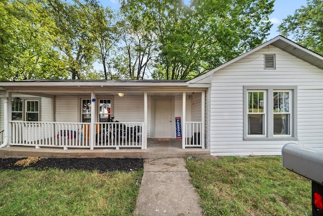 view of front of property featuring covered porch and a front lawn