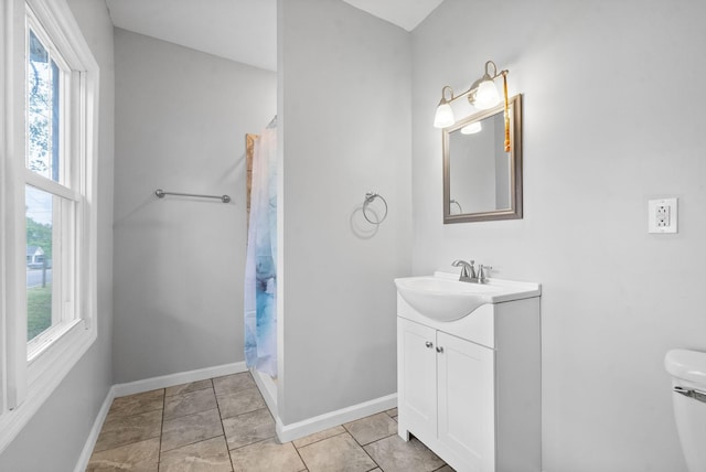 bathroom with walk in shower, tile patterned floors, vanity, and toilet