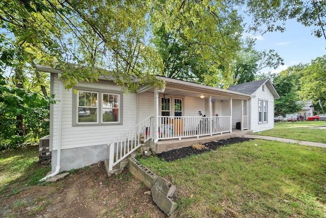 single story home featuring a porch, central AC unit, and a front lawn