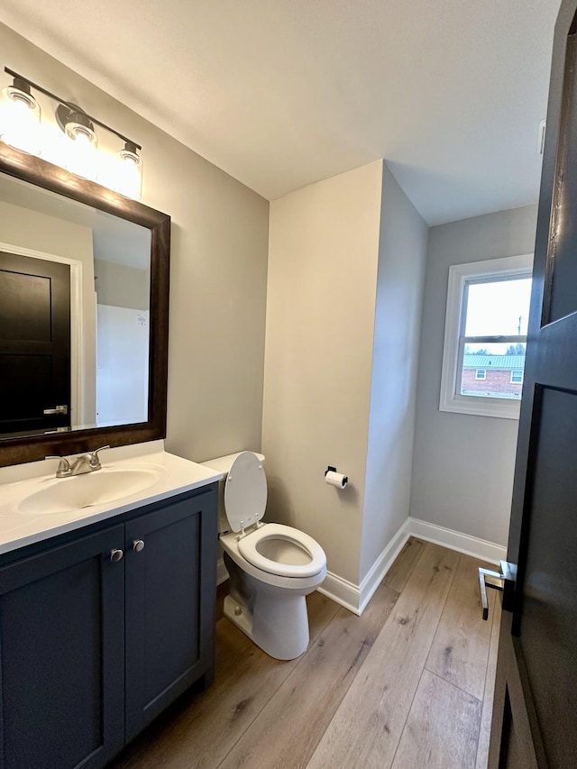 bathroom with wood-type flooring, toilet, and vanity