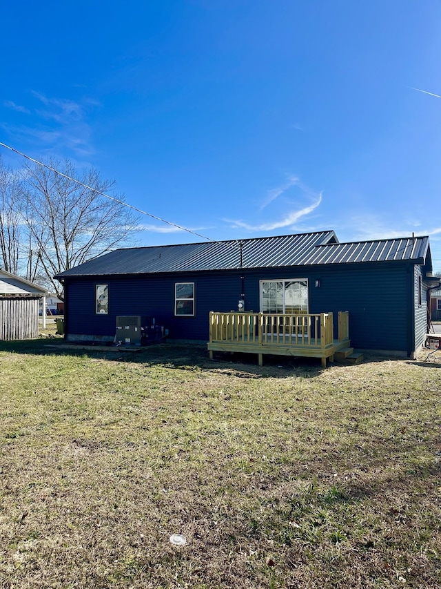 back of house featuring a wooden deck and a yard