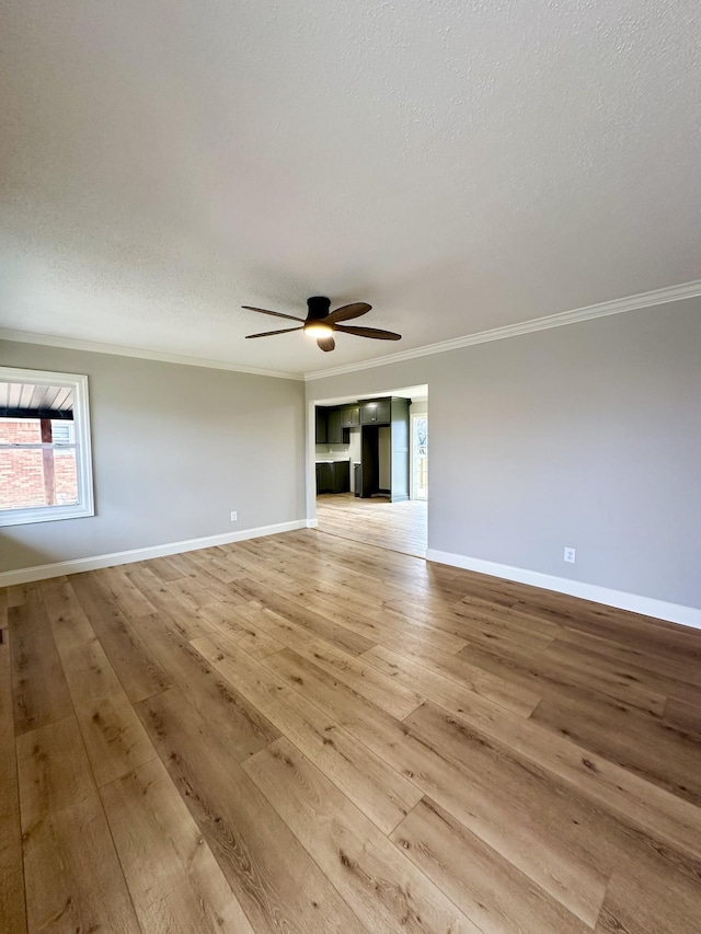 spare room featuring crown molding, ceiling fan, light hardwood / wood-style floors, and a textured ceiling