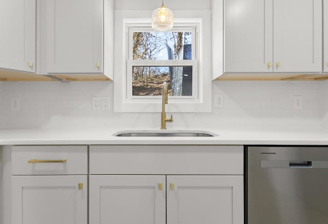 kitchen with tasteful backsplash, dishwasher, sink, white cabinets, and hanging light fixtures