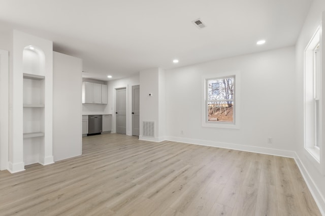 unfurnished living room with built in features and light wood-type flooring