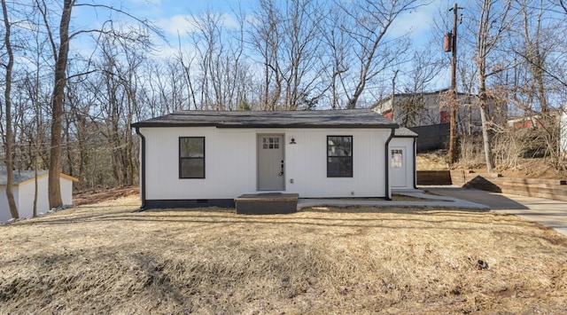 view of front of property featuring a storage shed