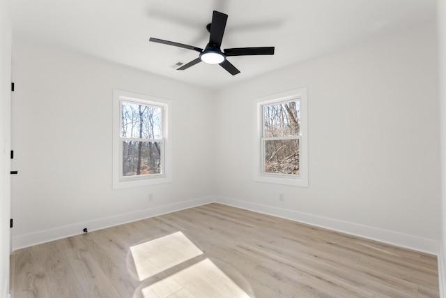 spare room with ceiling fan, a healthy amount of sunlight, and light wood-type flooring