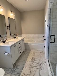 full bathroom featuring shower with separate bathtub, vanity, and toilet