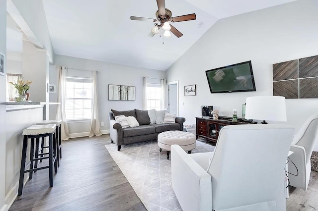 living room with ceiling fan, high vaulted ceiling, and light wood-type flooring