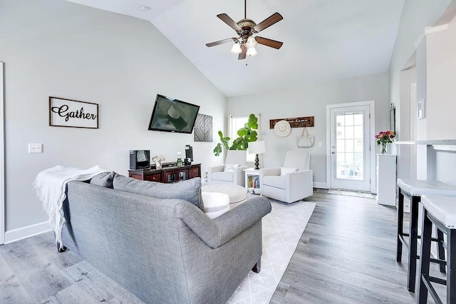 living room featuring ceiling fan, high vaulted ceiling, and light wood-type flooring