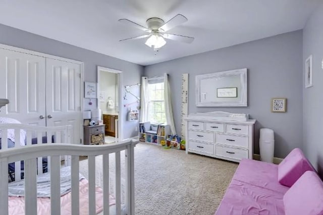 carpeted bedroom with ensuite bath, ceiling fan, and a closet