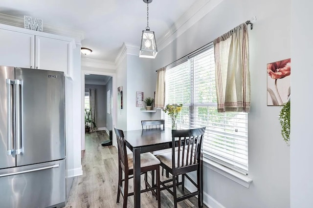 dining area featuring ornamental molding and light hardwood / wood-style floors