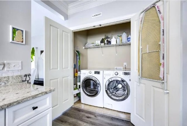 laundry area with crown molding, dark hardwood / wood-style floors, and washer and dryer