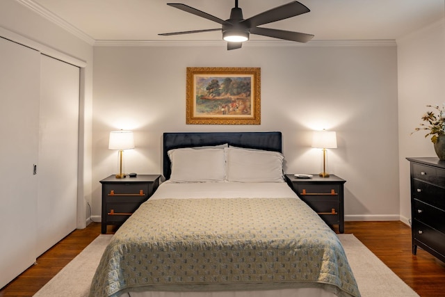 bedroom with ornamental molding, dark wood-type flooring, ceiling fan, and a closet