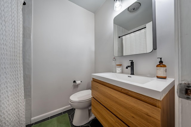 bathroom featuring tile patterned flooring, vanity, toilet, and walk in shower