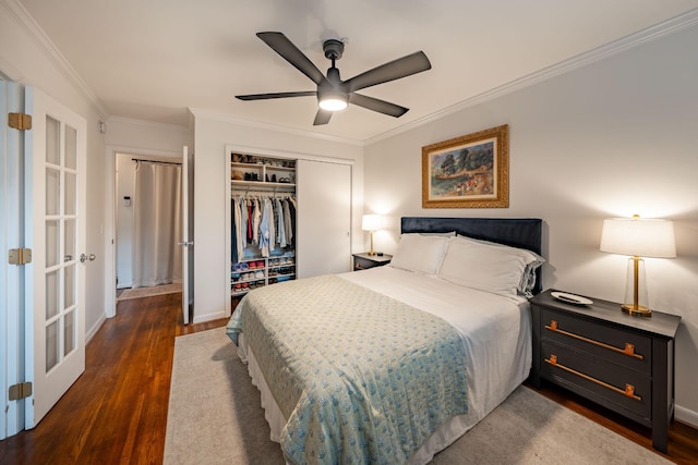 bedroom with ornamental molding, dark hardwood / wood-style floors, ceiling fan, and a closet