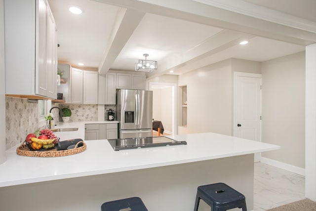 kitchen with sink, a breakfast bar area, kitchen peninsula, and stainless steel fridge with ice dispenser