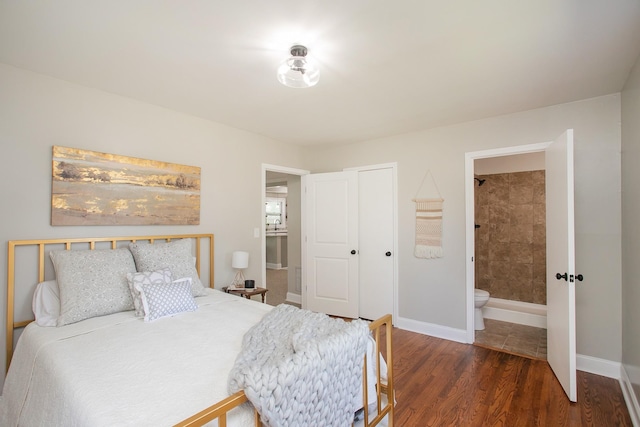 bedroom featuring ensuite bath, dark wood-type flooring, and a closet