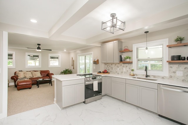 kitchen featuring sink, gray cabinets, kitchen peninsula, pendant lighting, and stainless steel appliances