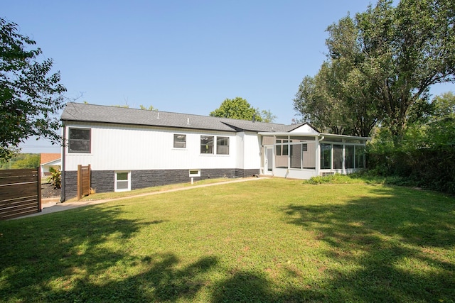 back of house with a yard and a sunroom