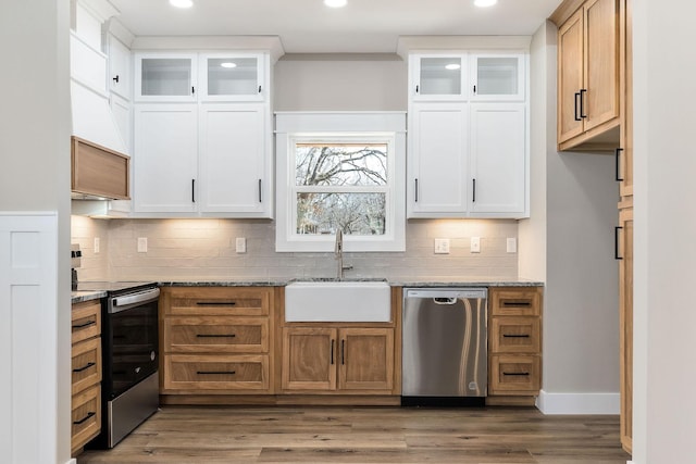 kitchen with stainless steel appliances, white cabinetry, light stone countertops, and sink