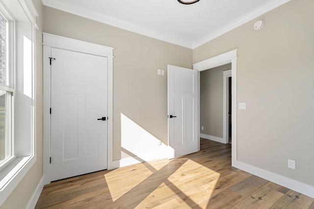 spare room with crown molding and light hardwood / wood-style floors