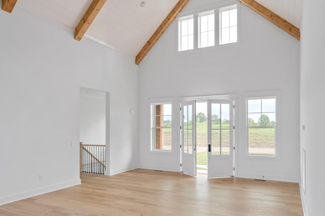 interior space featuring high vaulted ceiling, light hardwood / wood-style floors, and beamed ceiling