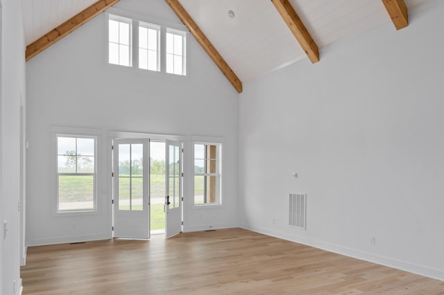 unfurnished living room featuring high vaulted ceiling, beam ceiling, and light hardwood / wood-style floors