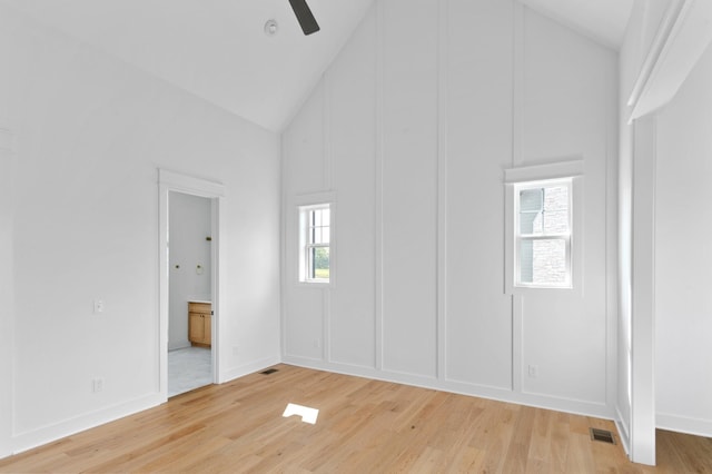 empty room with hardwood / wood-style flooring, high vaulted ceiling, and ceiling fan